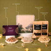Gifteet gourmet gift set with eco-friendly box, cashews, almonds, and floral diya on a green background.
